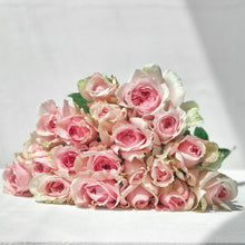 stacked pink bi colored roses with ruffled edges and light pink cream tones with darker pink on the outer petals 
